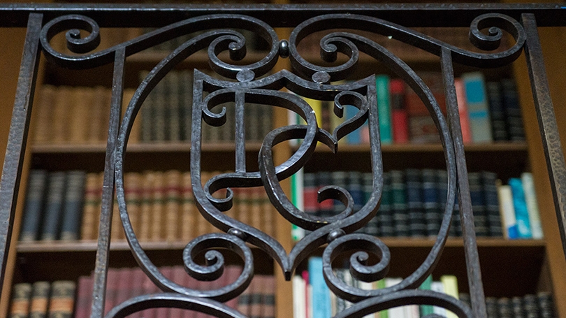 an iron bannister in Baker Library with the letters D and C worked in a fancy script